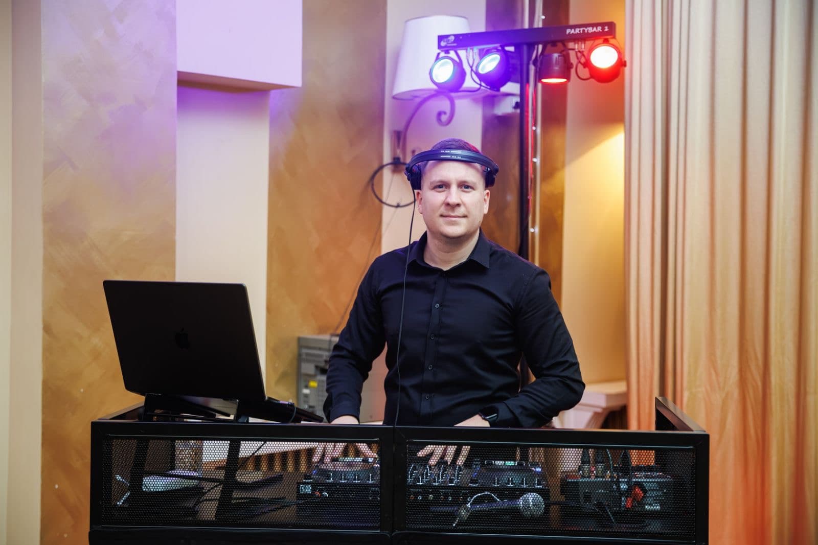 DJ Yuppie za pultom u sali, uz rasvetu